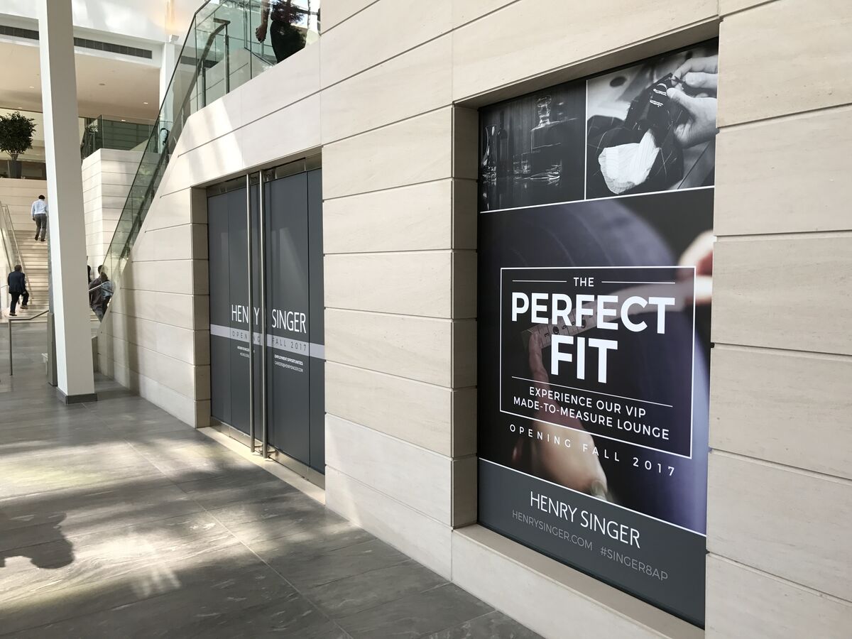 The Perfect Fit wrap beside branded Henry Singer doors in the atrium